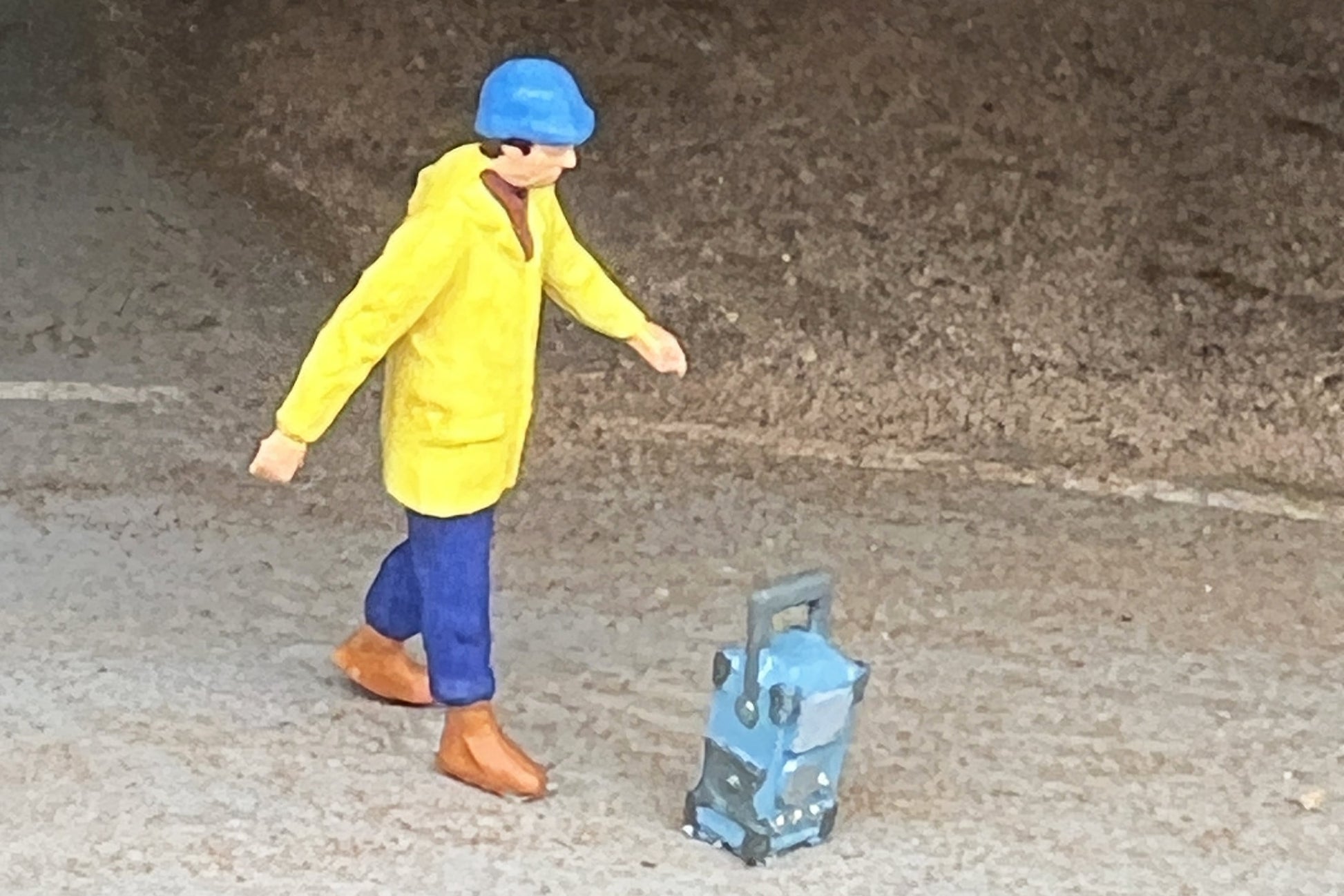 Eine Modellfigur im Maßstab H0 läuft zu einem Baustellenradio von Dorr Modellbau