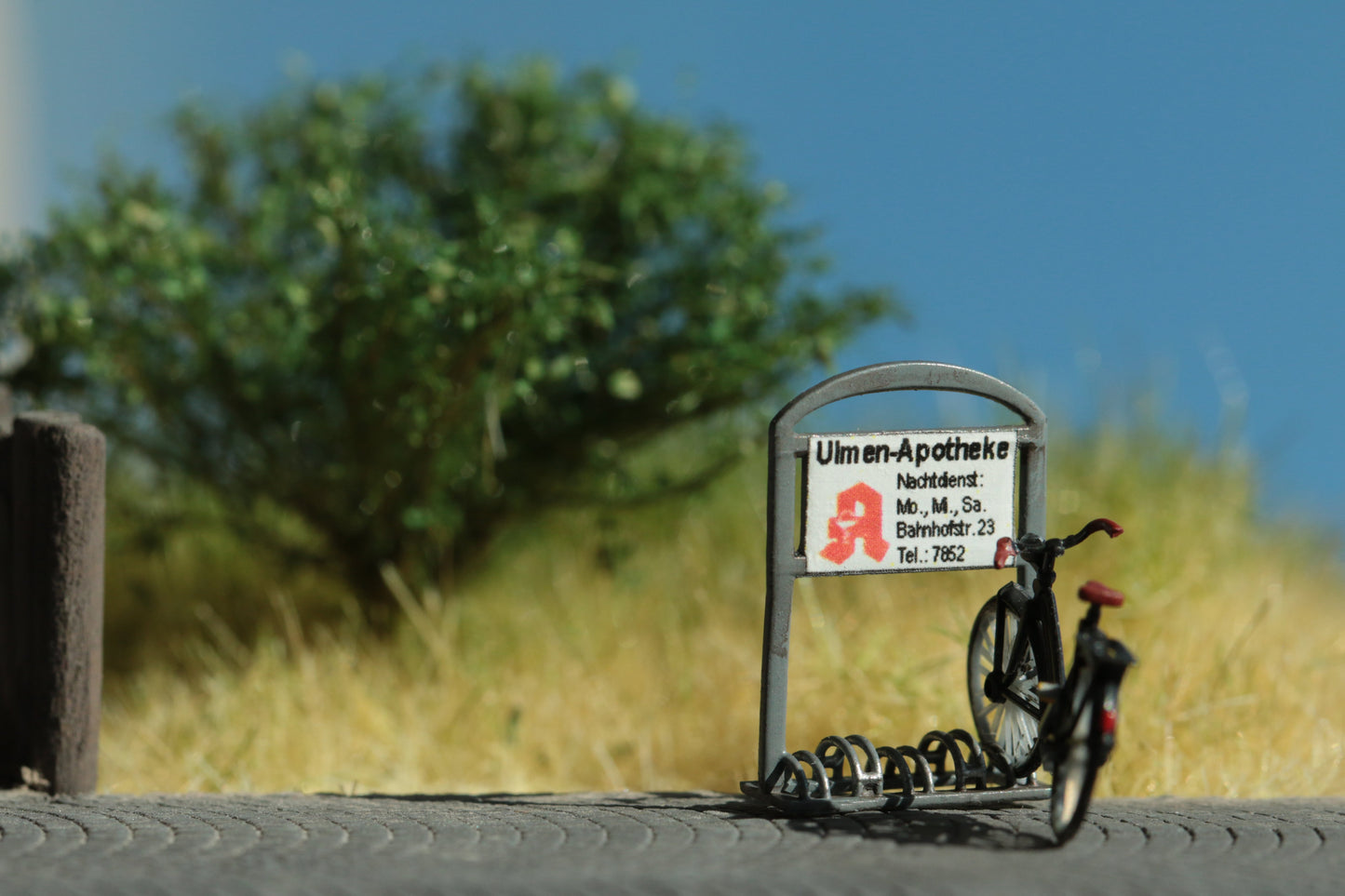 Maßstabsgetreuer Bausatz für einen Fahrradständer  mit Werbetafel einer Apotheke im Maßstab H0 (1:87
