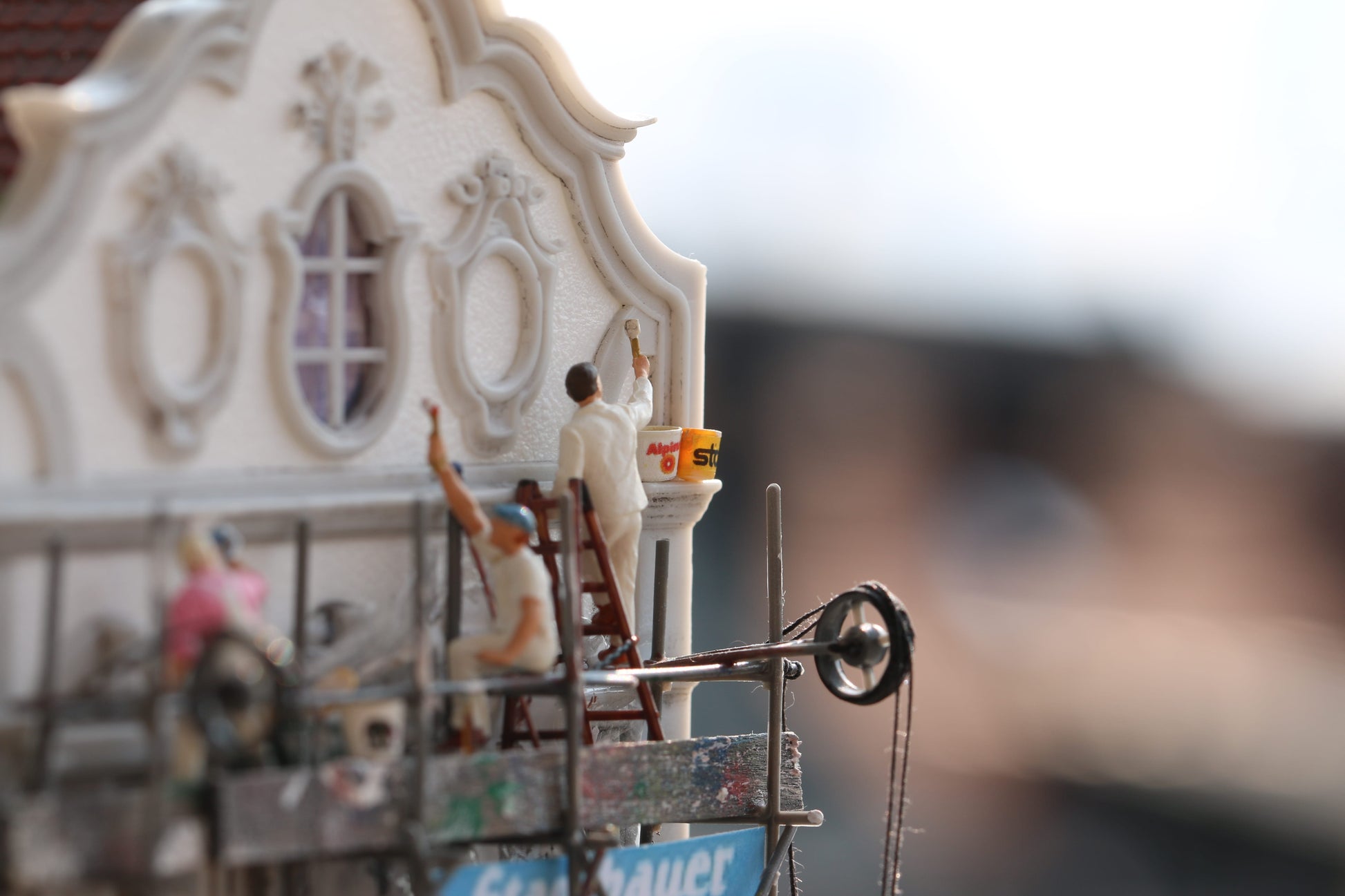 Maler sitzen auf einem Gerüst und malen Farbe aus Dorr Modellbau Eimern im Maßstab H0 1:87