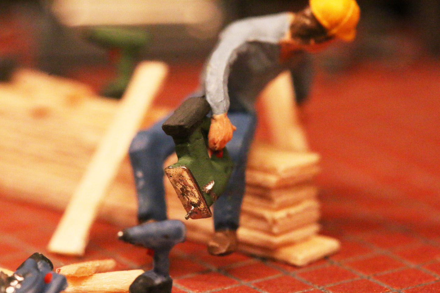 Ein Arbeiter hält eine Stichsäge im Mastab H0 1:87 von DorrModellbau.