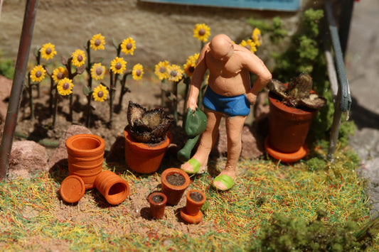 Modellbahn Figur mit Gießkanne neben Dorr Modellbau Blumentopf Set im Maßstab H0 1:87