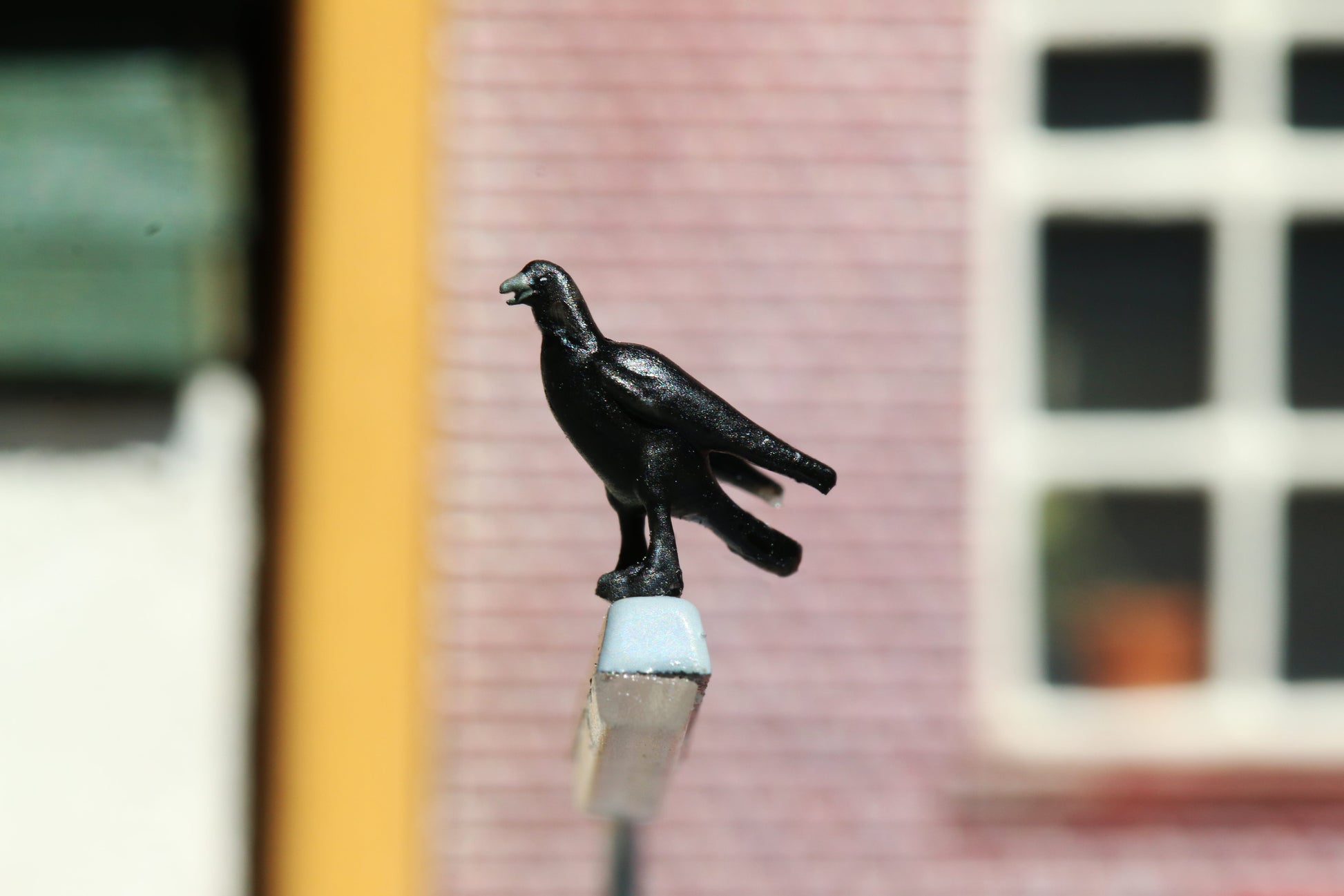 Eine Krähe von Dorr Modellbau im Maßstab 1:87 sitzt auf einer Straßenlaterne.
