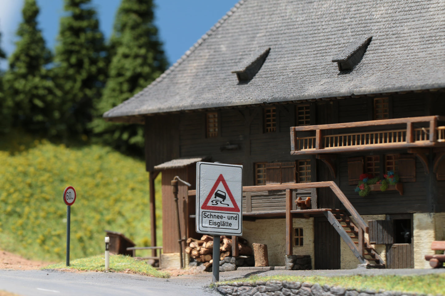 Schild für eine Gefahrenstelle mit Schnee und Eisglätte von DorrModellbau vor der Faller Ölermühle im Maßstab H0 1:87