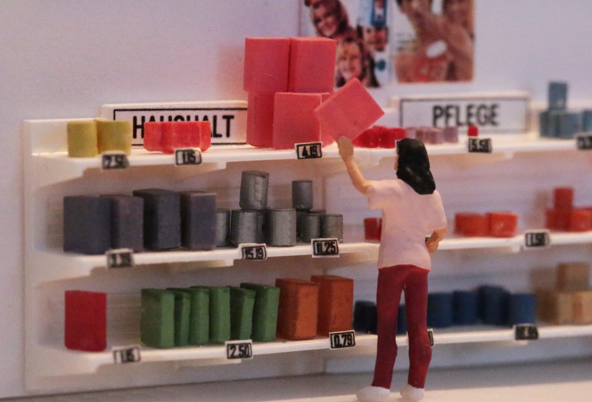 Eine Frau greift nach einer Packung die in einem Ladenregal von Dorr Modellbau steht. Maßstab 1:87.