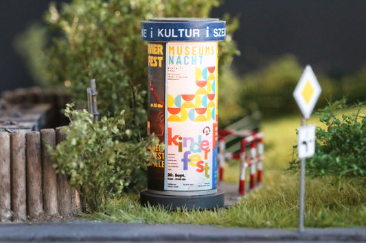 Litfasssäule mit Kunst und Kultur- Plakaten von DorrModellbau auf einer Modellbahnanlage