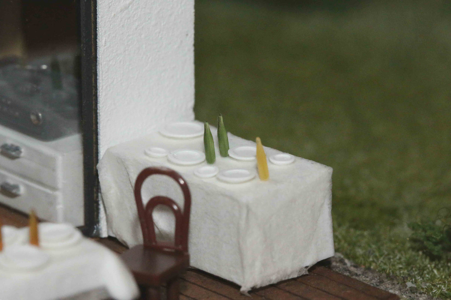 Gestaltungsvorschlag - DorrModellbau Teller-Set Bausatz auf einem Tisch auf der Terrasse eines Modellhauses