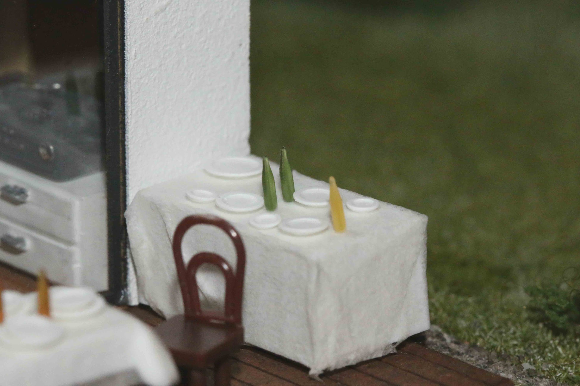 Gestaltungsvorschlag - DorrModellbau Teller-Set Bausatz auf einem Tisch auf der Terrasse eines Modellhauses