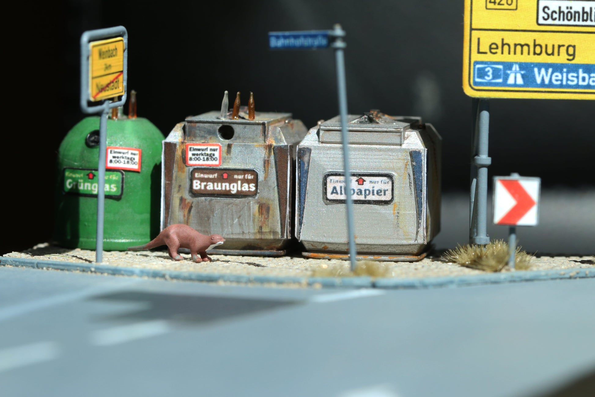 Ein Otter im Maßstab 1:87 läuft an Glascontainern von Dorr Modellbau vorbei.